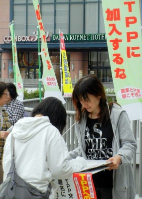 TPP参加交渉からの撒退を求める署名に応じる女性(左)=10月4日、水戸市