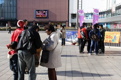 消費税増税反対や秘密保護法の撤廃を求める署名に応じる男性(左)や中学生たち=12月25日、水戸市