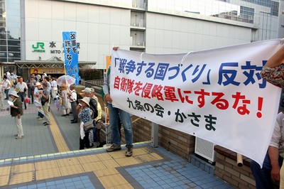 水戸駅北口の通路両側に横断幕やのぼり旗、プラカードを掲げて集団的自衛権行使の容認反対や秘密保護法の廃止をアピールする人たち=6月18日夕、水戸市