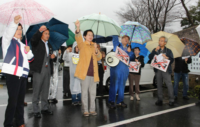 「茨城の空にオスプレイは来るな」と唱和する抗議行動の参加者たち=10月22日、茨城県小美玉市・航空自衛隊百里基地正門前