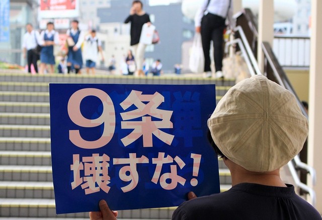「9条壊すな！」のプラカードを掲げる人=7月2日、水戸市