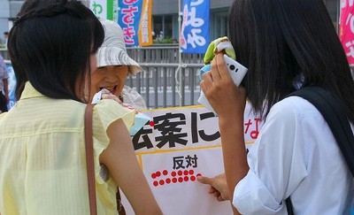 「戦争法案」の賛否を問うシール投票で「反対」欄にシールをはる女性=7月29日夕、水戸市