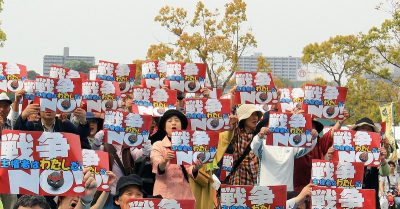 「戦争NO!」のカードをいっせいに掲げる憲法フェスティバル参加者=5月3日、水戸市