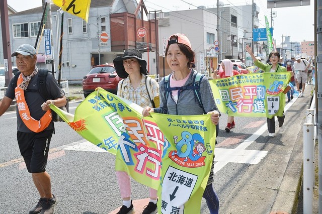 暑い中を行進する参加者ら
