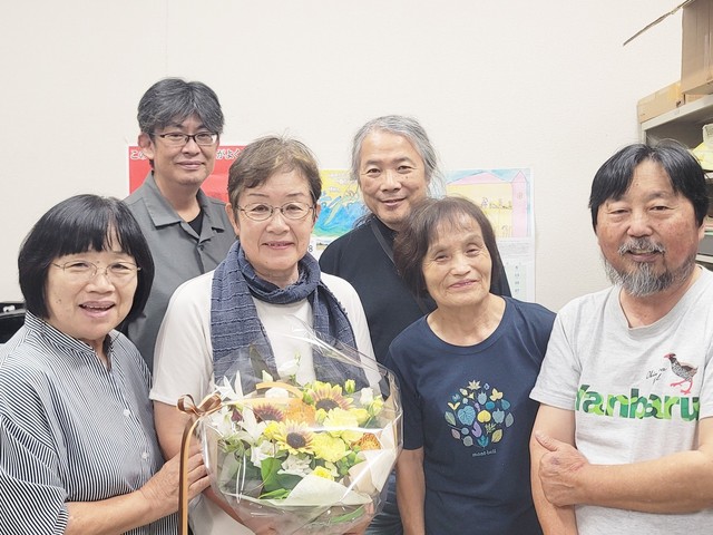 開票結果を受け、事務所に集まった支援者からねぎらいの花束を受け取る山中氏
