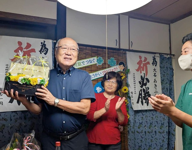 開票結果を受け、ねぎらいの花束を受け取り、あいさつする大名氏