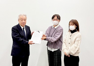 志田教育長に署名を渡す保護者たち