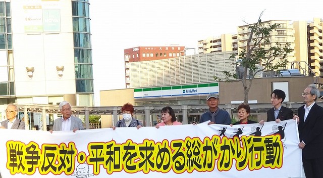 横断幕を掲げてアピールする参加者