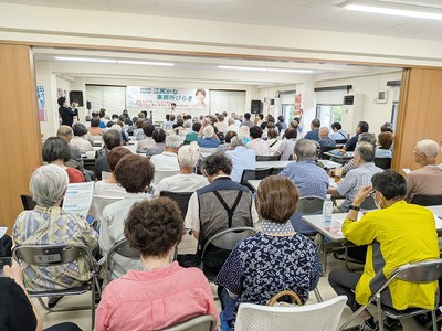 12月の県議選勝利へ、会場あふれる参加者が応援に駆けつけた事務所開きで、あいさつする江尻氏