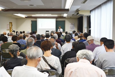鈴木氏（正面）の講演を聞く会場いっぱいの参加者
