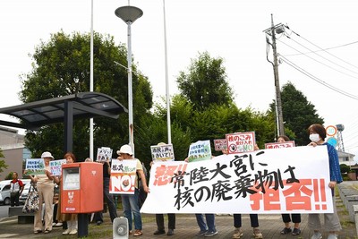 市役所の出入り口付近で抗議の声を上げる参加者たち
