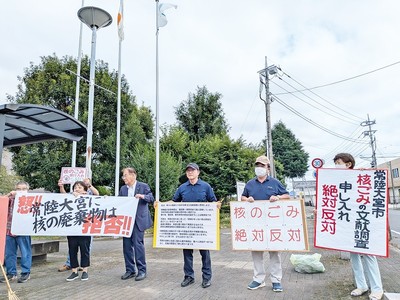 手作りプラスターを掲げる市民たちとともに抗議アピールに参加する小室市議