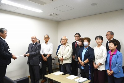 大森建設部長に公開質問状を渡す田中氏と「市民の会」のメンバーたち